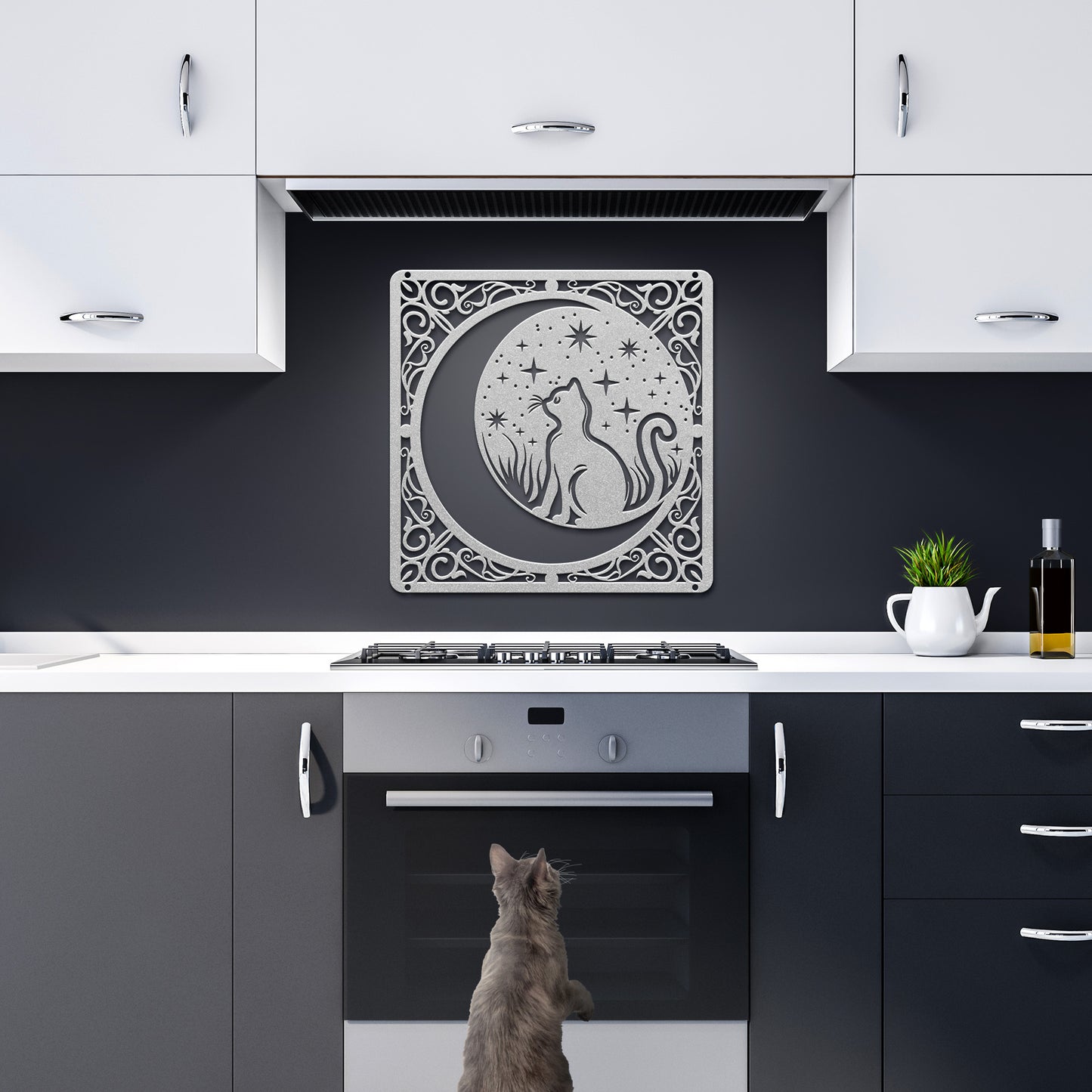 A copper home decor metal sign of a cat inside a crescent moon next to a field of stars. All of this is bordered by floral vines. It hangs in a dark kitchen above a grey cat.