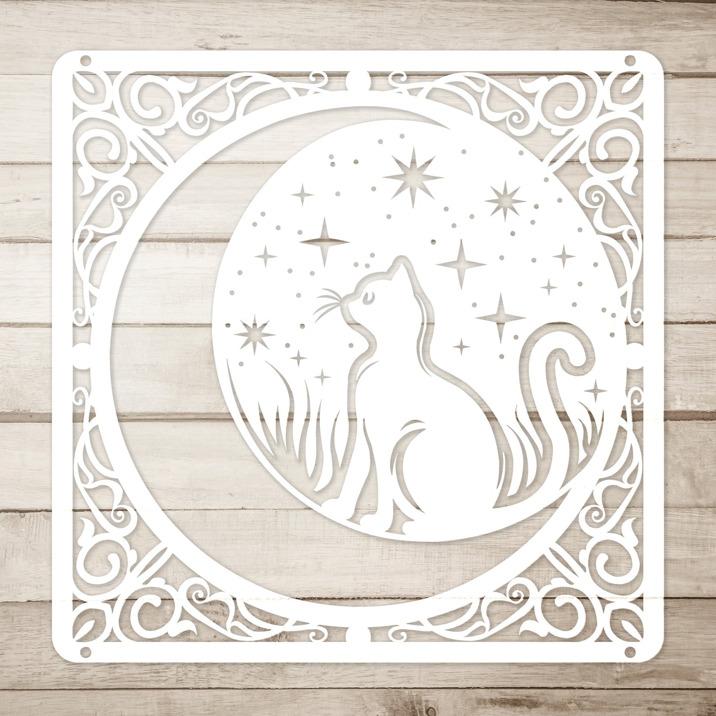 A white home decor metal sign of a cat inside a crescent moon next to a field of stars. All of this is bordered by floral vines. Simple wood background.