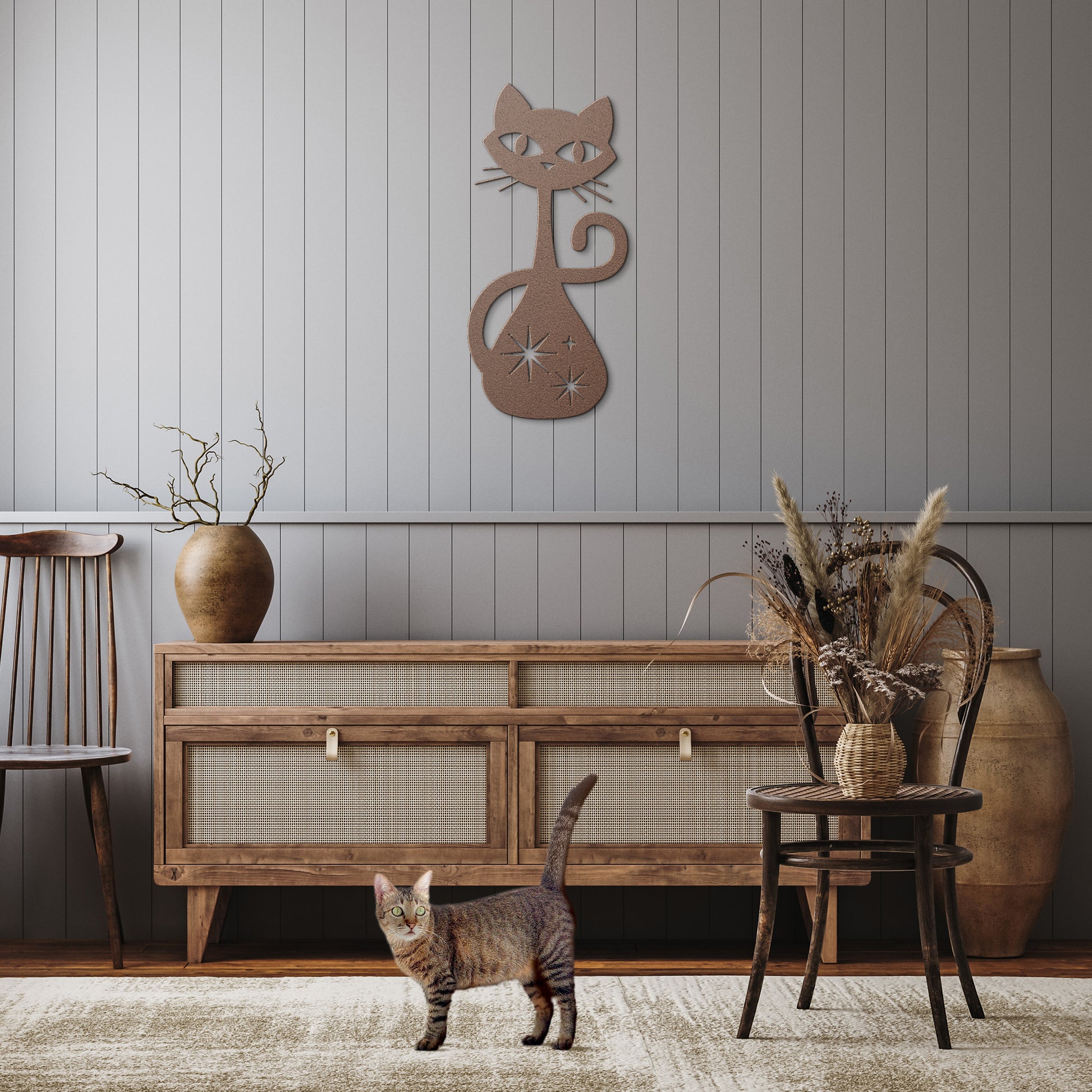 A copper atomic cat metal wall art hanging in a rustic hallway.
