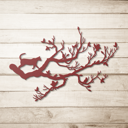 A red metal wall art decor of a cat stalking birds on a branch on a simple wood background.