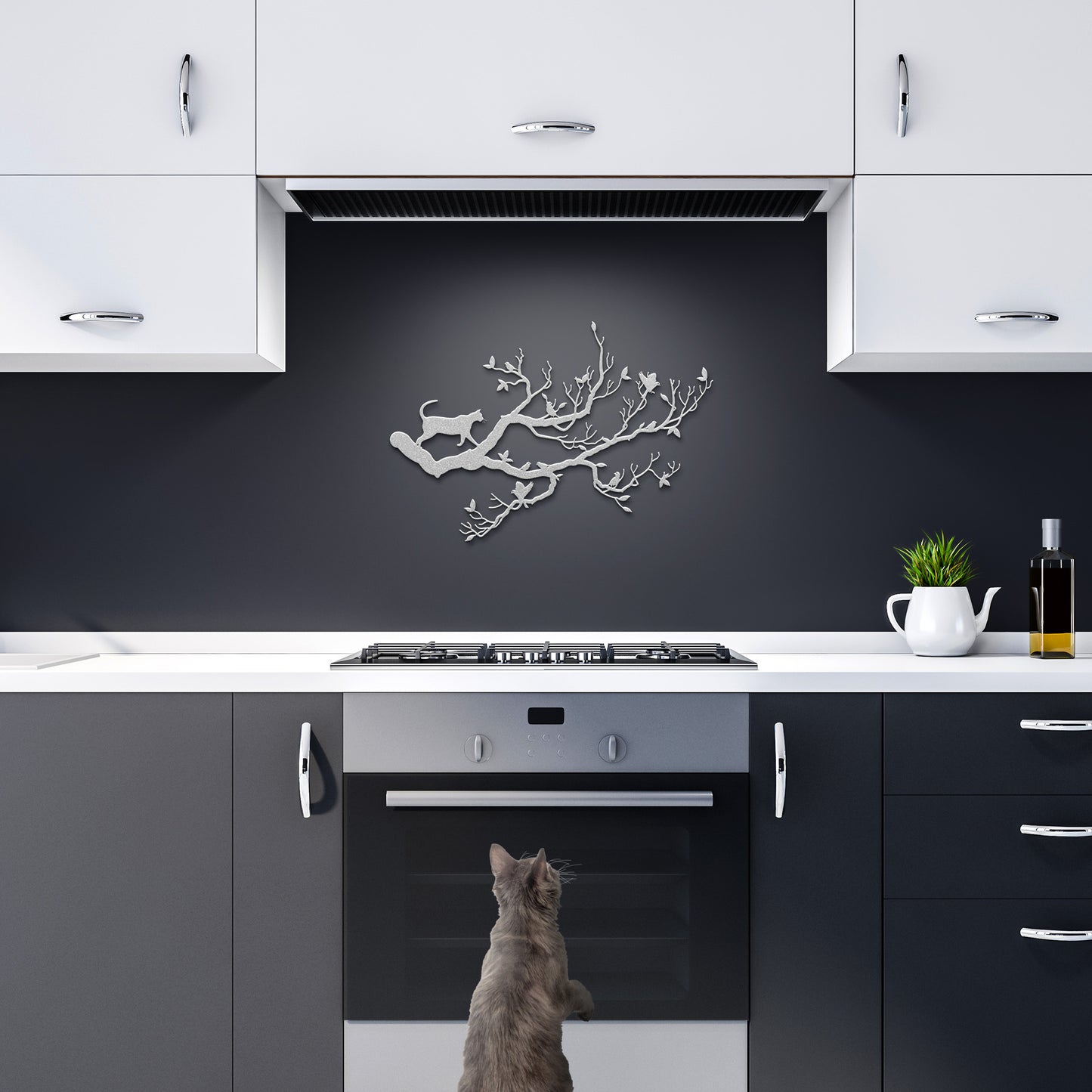 A metal wall art decor of a cat stalking birds on a branch hanging in a dark kitchen.