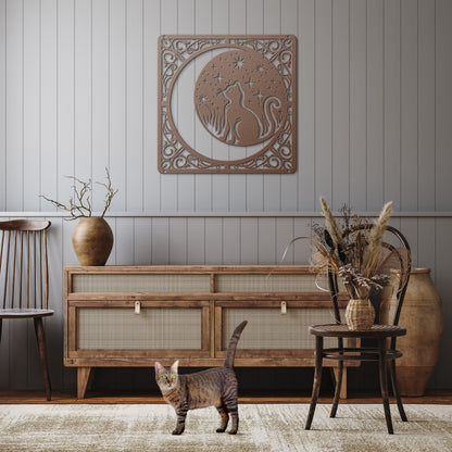A copper home decor metal sign of a cat inside a crescent moon next to a field of stars. All of this is bordered by floral vines. It hangs on the wall of a rustic hallway above a tabby cat.