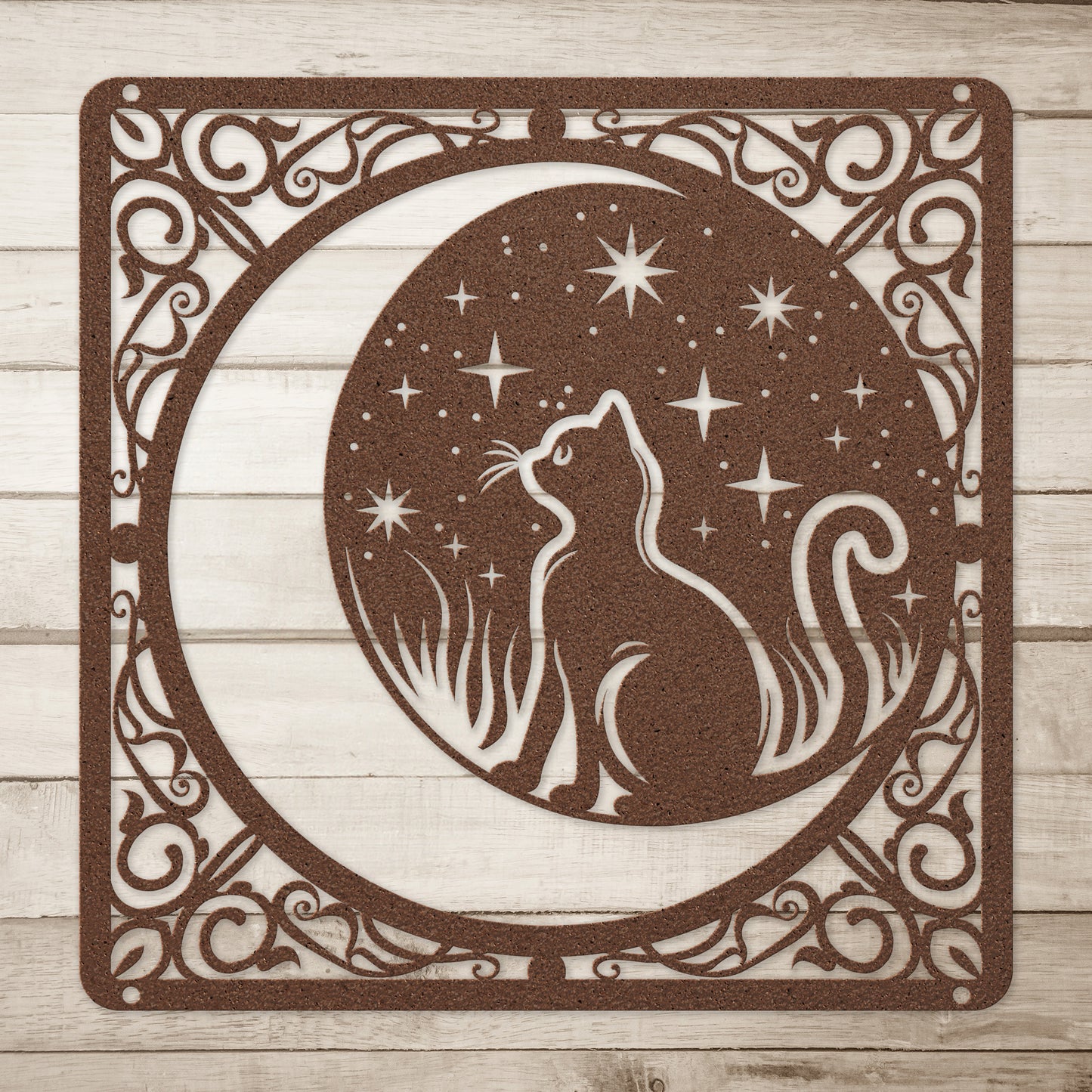 A copper home decor metal sign of a cat inside a crescent moon next to a field of stars. All of this is bordered by floral vines. Simple wood background.