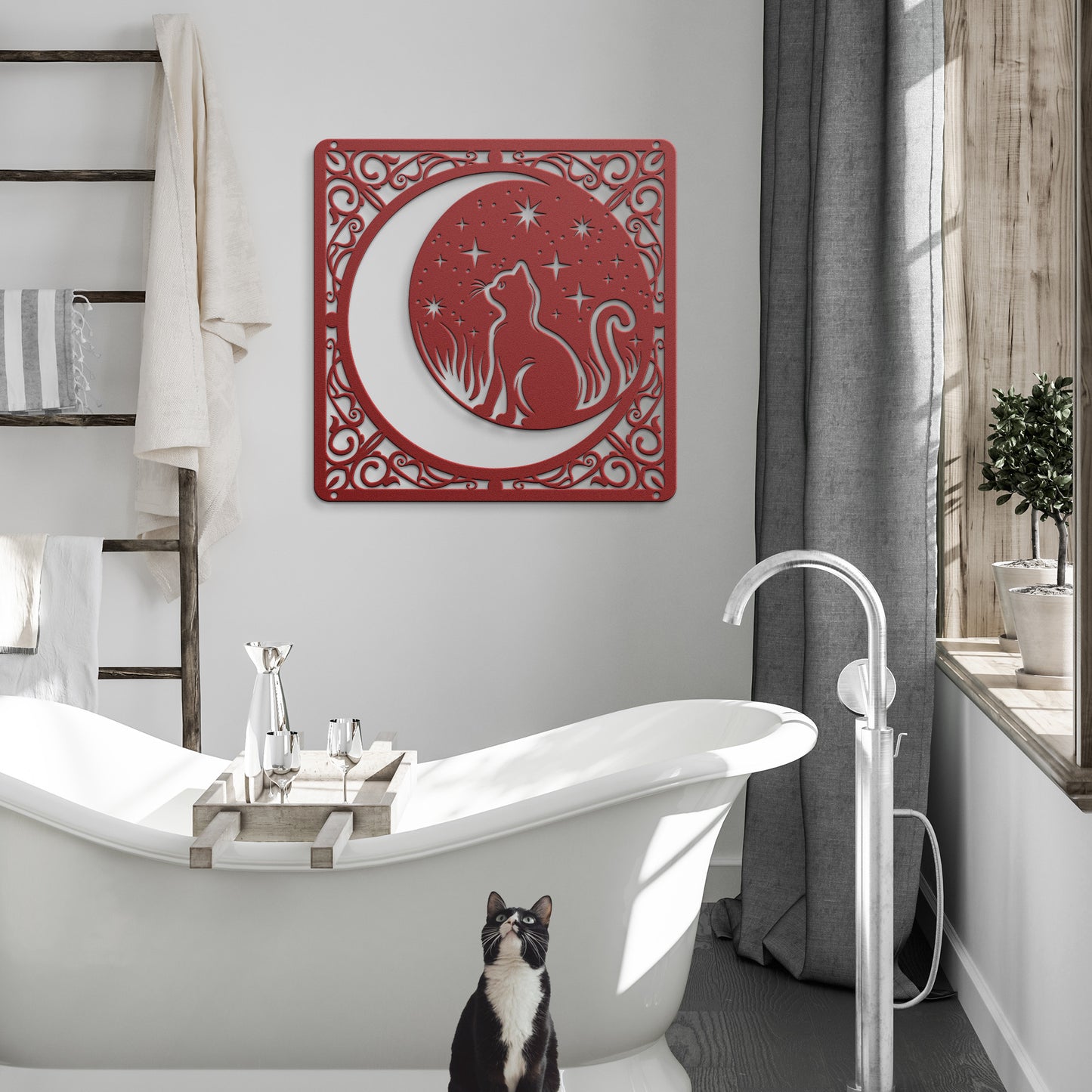 A red home decor metal sign of a cat inside a crescent moon next to a field of stars. All of this is bordered by floral vines. It hangs in a modern bathroom above a tuxedo cat.