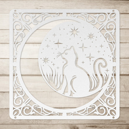 A silver home decor metal sign of a cat inside a crescent moon next to a field of stars. All of this is bordered by floral vines. Simple wood background.
